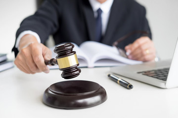 Male Judge lawyer In A Courtroom Striking The Gavel on sounding block