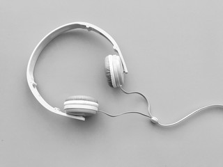 Closeup A white headphone on light gray background. Gadgets on gray background. Top view with Copy space. Selective focus.