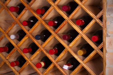 Bottles of wine on wooden shelves in wine cellar