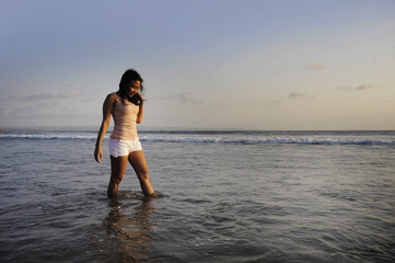 young happy and excited Asian woman having fun enjoying playful and free at sunset beach in tourism vacation