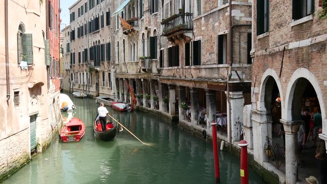 Gondola in a canal and Venetian flag in Venice Italy