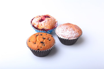Homemade Blueberry and chocolate muffins with powdered sugar and fresh berries.