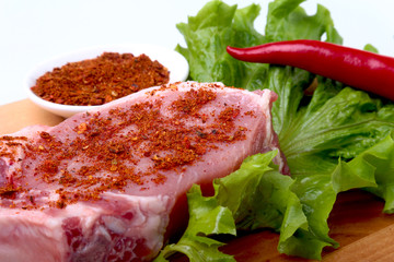 Raw pork chops with herbs and spices on cutting board. Ready for cooking.