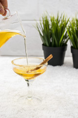 cold apple juice pouring in glass with cinnamon.