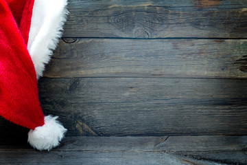 Obraz na płótnie Canvas Christmas background with Santa Claus hat on vintage boards 