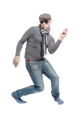 Naklejka premium Unshaven bald man wearing a cap, jeans, sunglasses and a scarf dancing a strange dance. Isolated