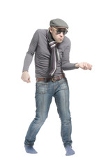 Fototapeta premium Unshaven bald man wearing a cap, jeans, sunglasses and a scarf dancing a strange dance. Isolated