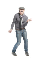 Unshaven bald man wearing a cap, jeans, sunglasses and a scarf dancing a strange dance. Isolated