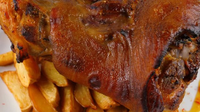 Pork knuckle with potatoes and vegetables, close-up view, loop, 4K, ProRes codec, 422 HQ, ISO 100