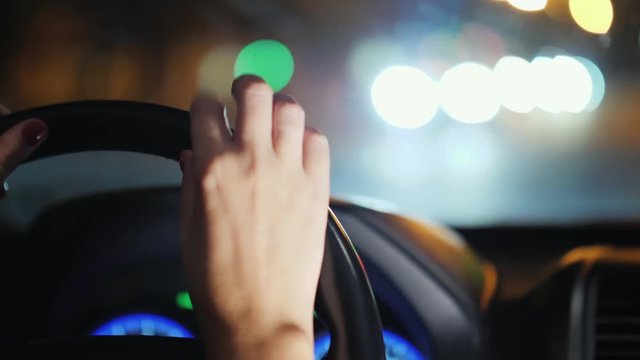 A woman's hand nervously drummed on the steering wheel of the car. Stand in traffic, uncertain driver