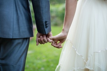 Wedding couple holding hands in garden