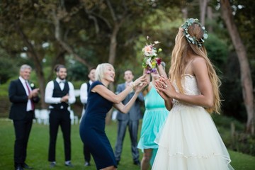 Fototapeta na wymiar Rear view of bride holding flower bouquet