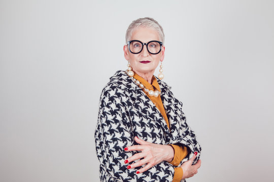 Stylish and elegant old woman in glasses on a white background.