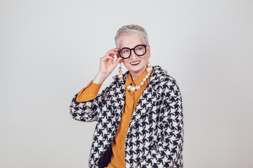 Stylish and elegant old woman in glasses on a white background.