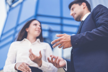 The business woman and man talk near the modern building
