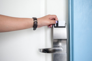 Woman hand opening hotel room door by keycard