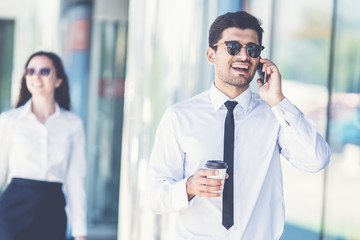 The businessman in sunglasses phone near the woman