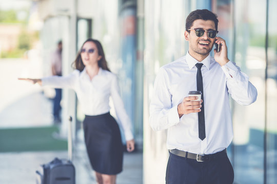 The handsome businessman in sunglasses phone near the woman