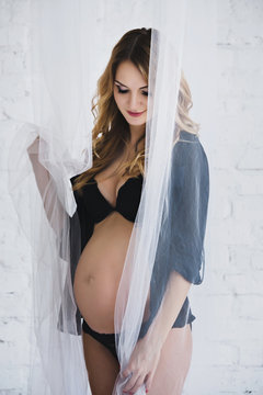Pregnant woman in lingerie in the room
