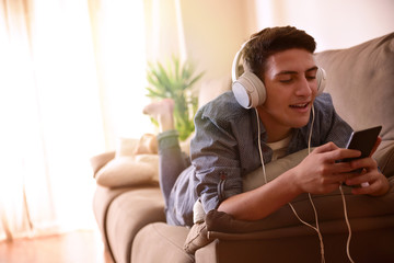 Teen singing and listening music with headphones lying face down