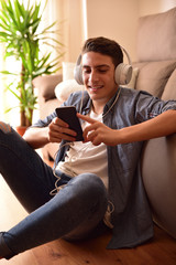 Teen sitting on floor using a smartphone at home vertical