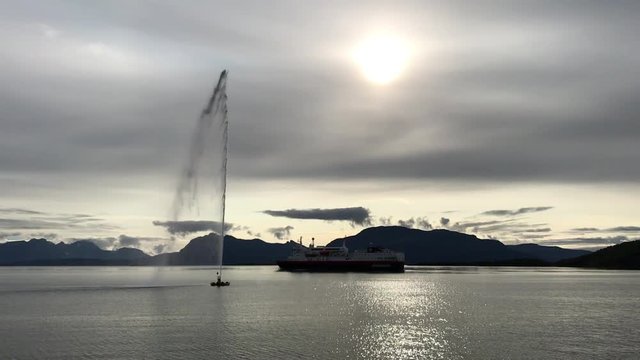 Fountain and Hurtigruten ferry in port in Harstad.Hurtigruten is a famous Norwegian cruise, ferry and cargo operator. The company was founded in 1893.