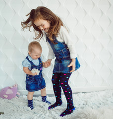 Pretty girls in jeans dresses jump on the floor