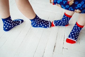 Children in spotted socks stand on the floor