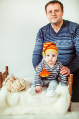 Father sits with a little son on a bed