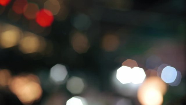 Full HD footage of colourful bokeh at urban shopping complex at night with ARTIFICIAL GRAIN effect for background concept.Retro Bokeh with grain.