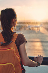 Girl at the airport window looking outside