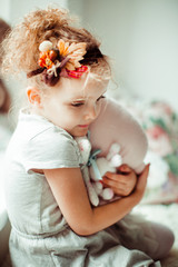 Charming little child sits between toys