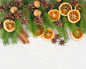 Fototapeta na wymiar Nuts, dried oranges and cones and spruse branch on a white