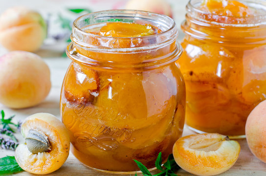 Apricot jam in a jar on a wooden table