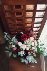 Rich wedding bouquet of roses and peonies lies on the chair