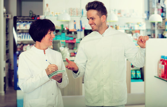 Pharmacist And Pharmacy Technician Posing In Drugstore