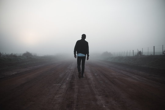 Man walking on misty path