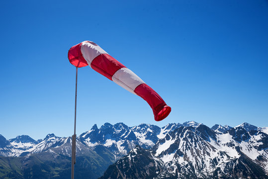 Windfahne in den schneebedeckten Alpen, blauer Himmel