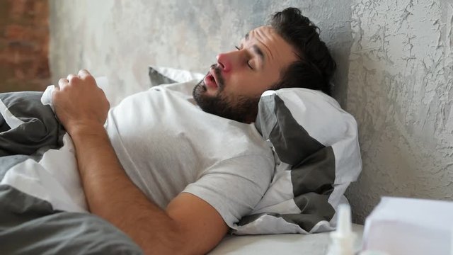 Ill gentleman blowing his nose while sneezing