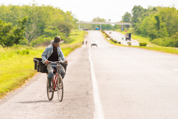 Obraz premium A man is riding along the road on a bicycle, Vinales, Pinar del Rio, Cuba. Copy space for text.