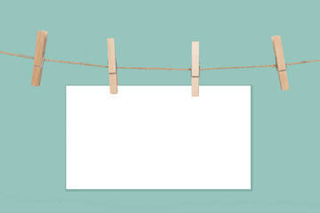 Rope with empty white paper frames with space for copy and clothespins on a blue background