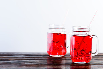 Wooden table top with two mason jars full of lemonade on light background, copyspace for text