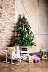 Fototapeta na wymiar Beautiful Christmas interior design. In the room decorated Christmas tree with gift under it, sled and small lamps. Concept of Christmas, winter and New Year