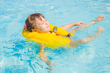 The child is bathing in the pool at the resort. Selective focus.  