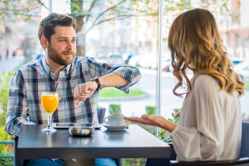 Man showing clock at his girlfriend, girlfriend late to date