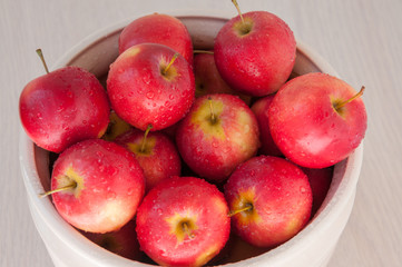 Many red apples on the table in a vase
