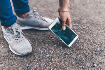 woman dropped mobile phone on the ground and smashed the screen