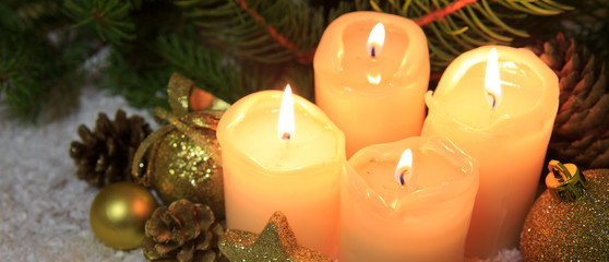 Four burning advent candles and Christmas decoration.