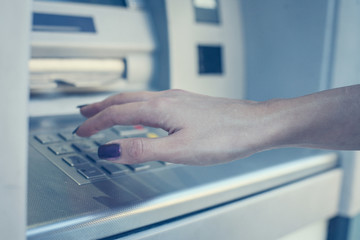 Hand of woman pressing keyboard at local  cash machine. Close up.