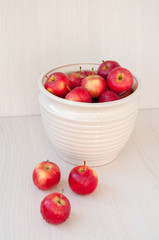 Many red apples on the table in a vase